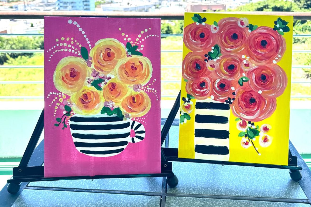 Two flower paintings displayed with an ocean view