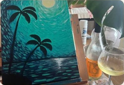 Finished tropical painting on an easel with drinks nearby