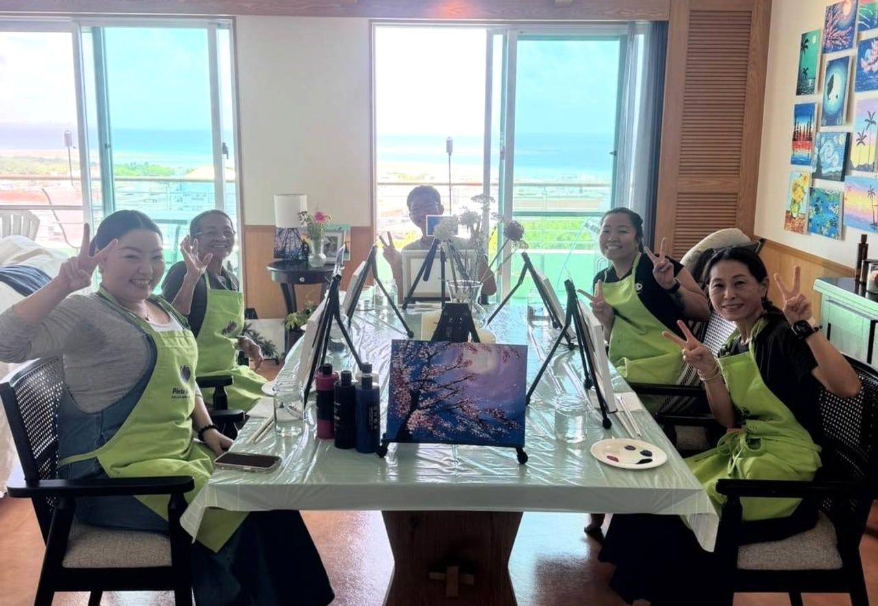 Pinto Beetle guests smiling during an ocean-view painting class