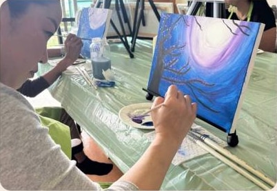 Guest painting fireworks during a Pinto Beetle class