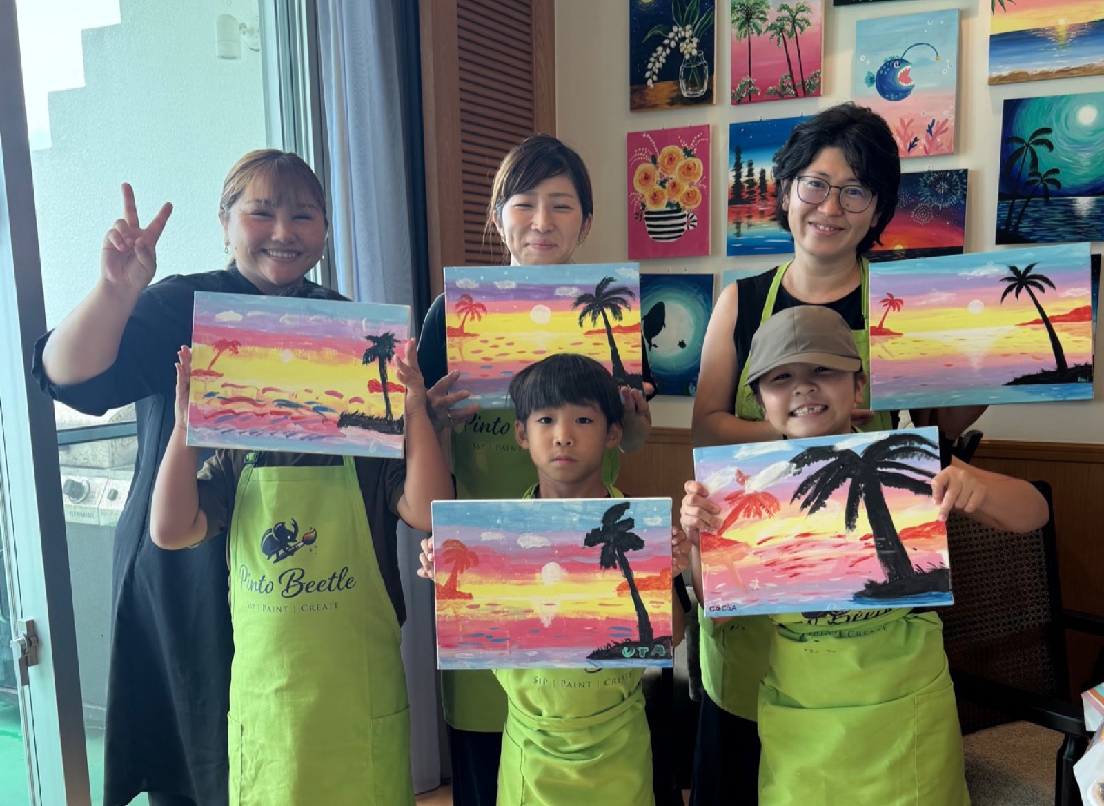 Pinto Beetle guests smiling with finished Sunset Paradise paintings