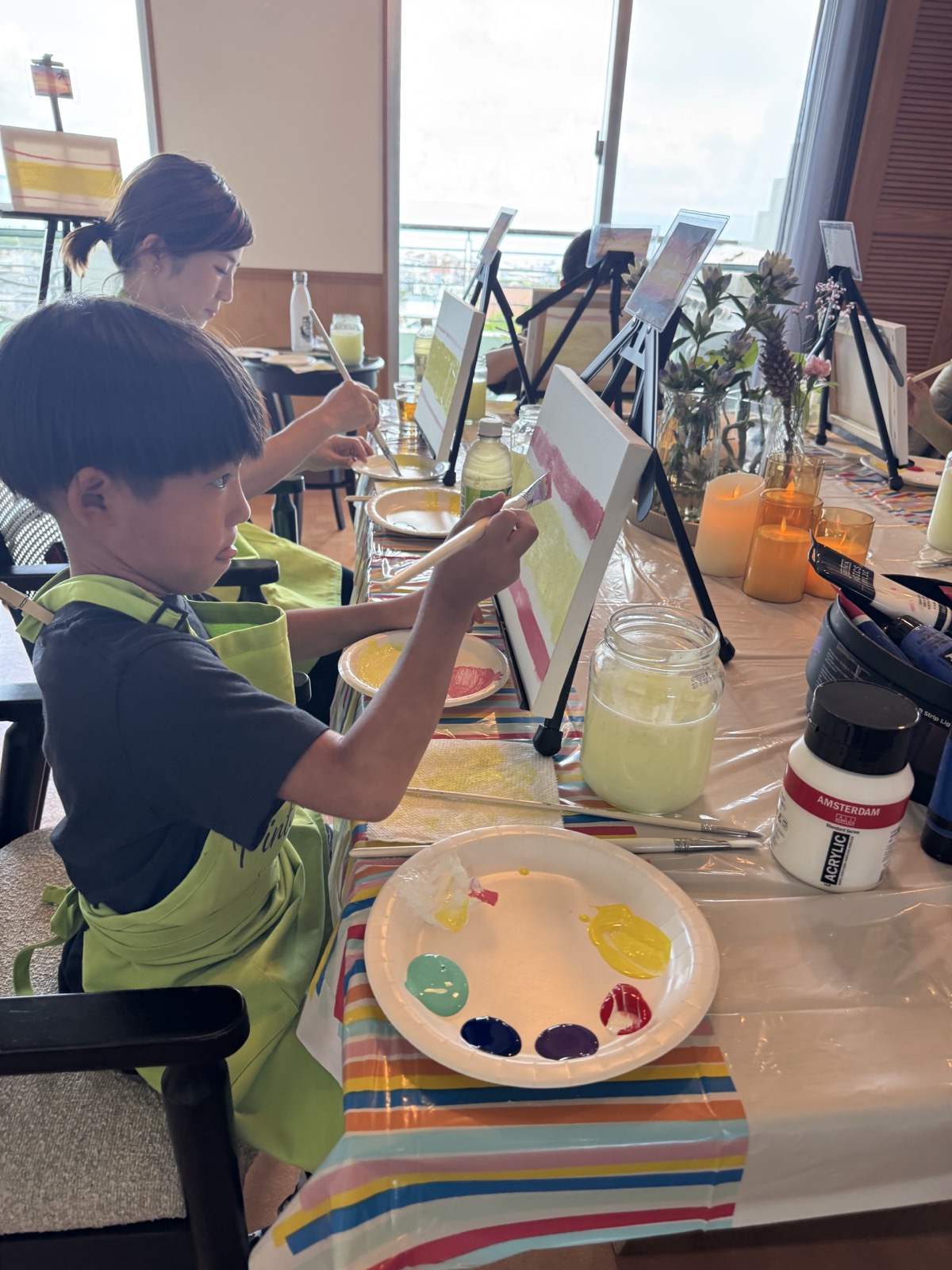 Pinto Beetle guests painting Sunset Paradise canvases around the studio table