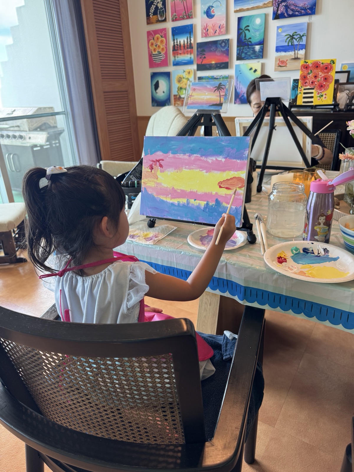 Young Pinto Beetle guest painting a colorful Sunset Paradise canvas