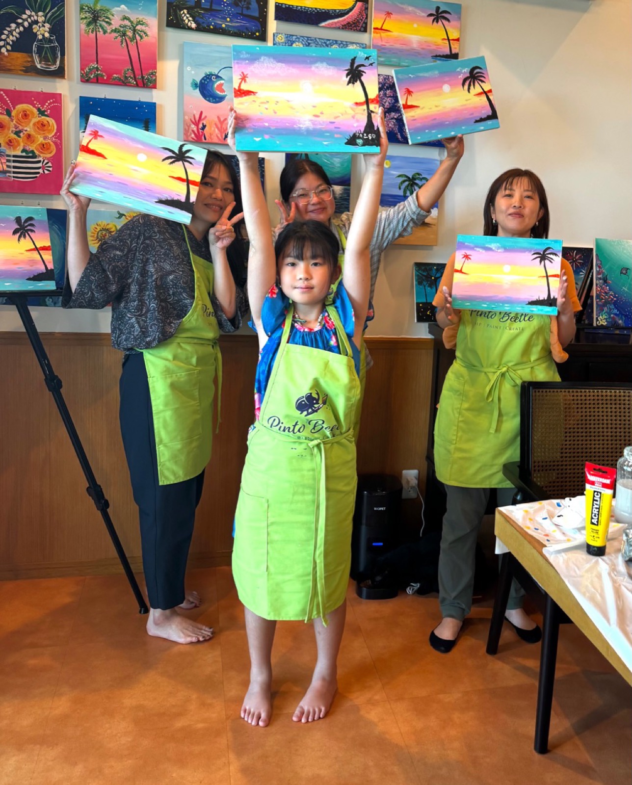Pinto Beetle guests holding finished Sunset Paradise paintings