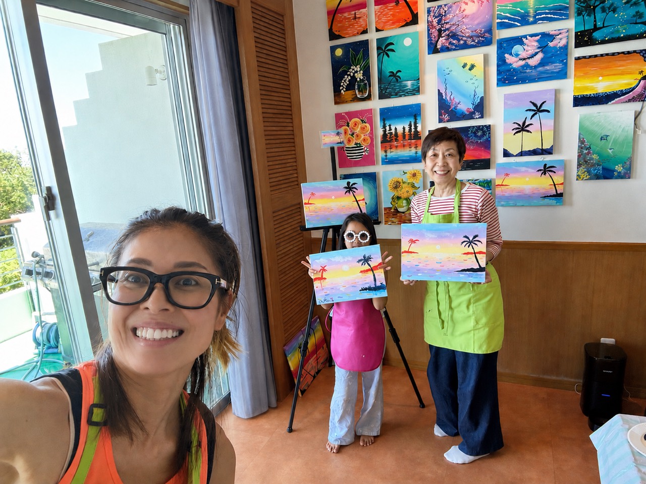 Pinto Beetle guests smiling with their finished tropical sunset paintings