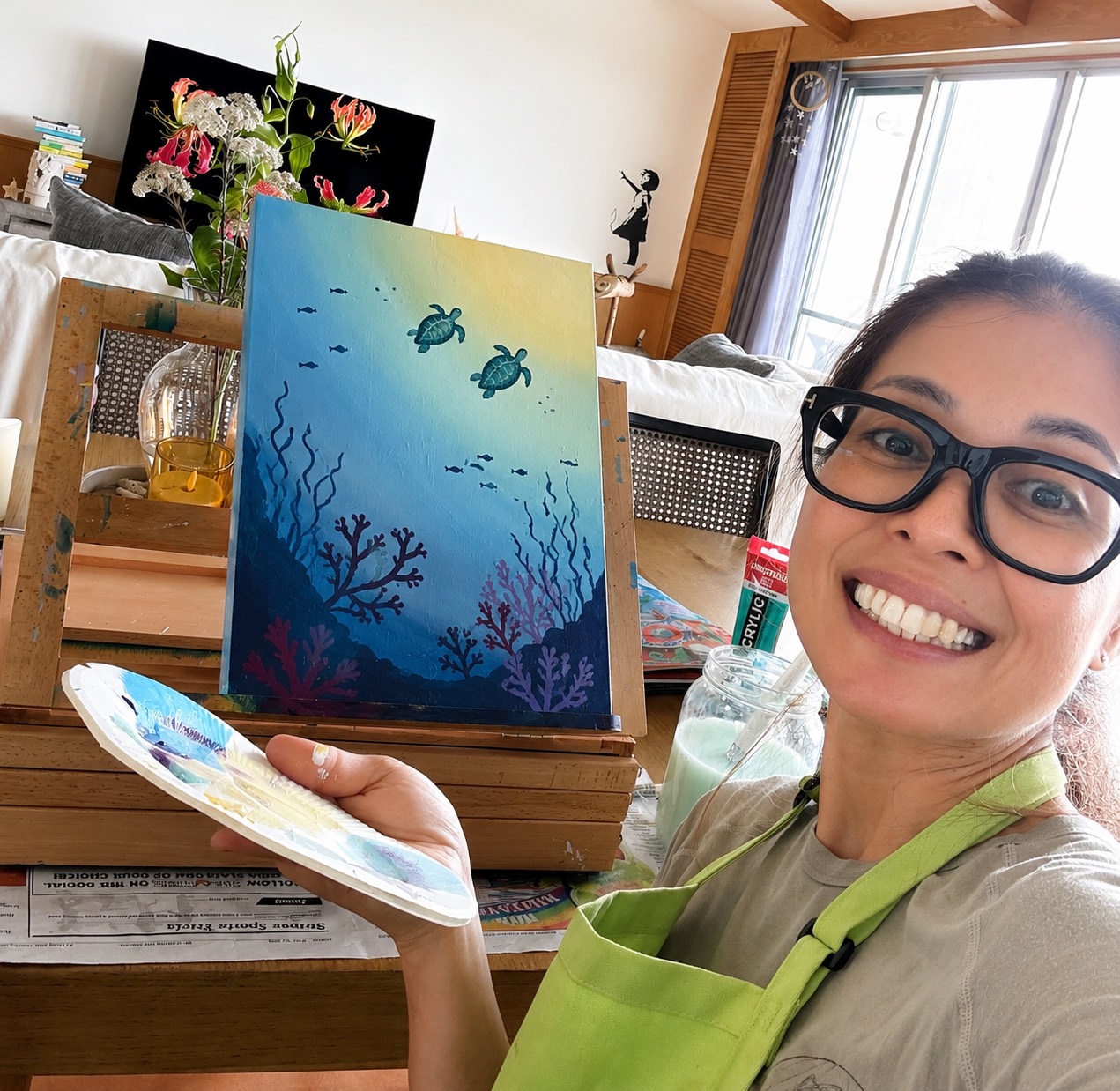 Miya smiling beside a finished sea turtle painting