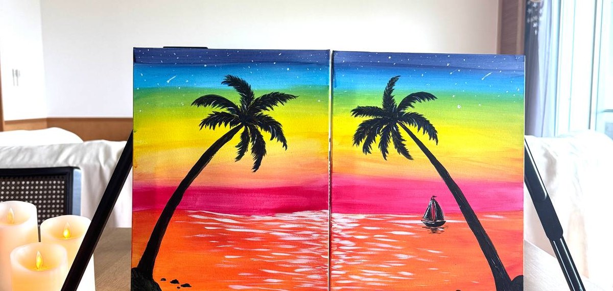 Finished tropical sunset pair paintings displayed with candles